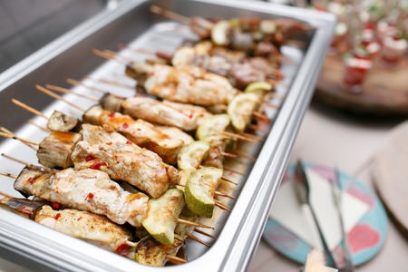 Breakfast buffet in hotel or catering. Grilled chicken on bamboo skewers, close up view, shallow depth of fieldの写真素材