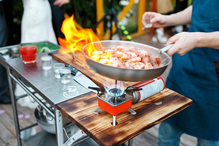 Flambe. Fried king prawns on iron pan. chief cook pours the alcohol and fire.の写真素材