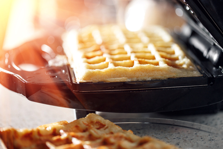 Freshly baked traditional Belgian waffles in iron waffle makerの写真素材