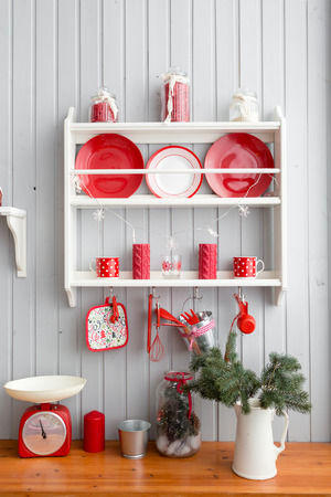 shelves with dishes. Interior light grey kitchen and red christmas decor. Preparing lunch at home on the kitchen concept.の写真素材