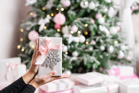 Female hands holding small elegant gift with ribbon. Holidays and celebration concept.の写真素材