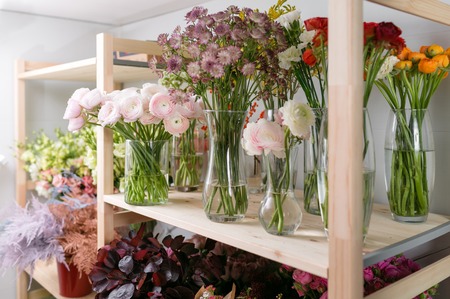 different varieties. Fresh spring flowers in refrigerator for flowers in flower shop. Bouquets on shelf, florist business.の写真素材