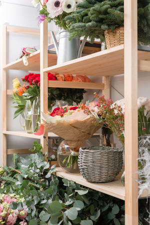 different varieties. Fresh spring flowers in refrigerator for flowers in flower shop. Bouquets on shelf, florist business.の写真素材
