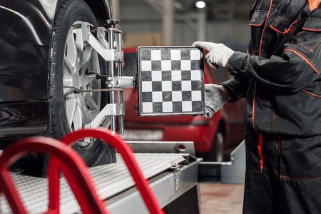 auto mechanic sets the car for diagnostics and configuration. Wheel alignment equipment on a car wheel in a repair stationの写真素材