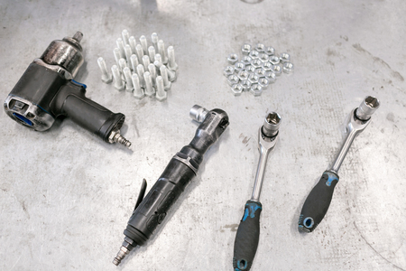 compressor wrench. Chromed screw nuts and bolts from above. Many screw nuts and bolts. Screw nuts and bolts of different sizes on a gray metal background.の写真素材