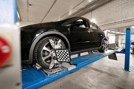 Grid sensor sets mechanic on auto. Car stand with sensors wheels for alignment camber check in...