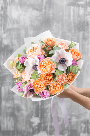 beautiful luxury bouquet of mixed flowers in woman hand. the work of the florist at a flower shopの写真素材