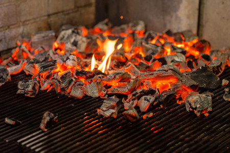 Typical Argentinian barbecue or asado. Burning wood in the grill and red hot coalsの写真素材