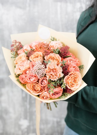 Beautiful luxury bouquet of mixed flowers in woman hand. the work of the florist at a flower shop. cute lovely girlの写真素材