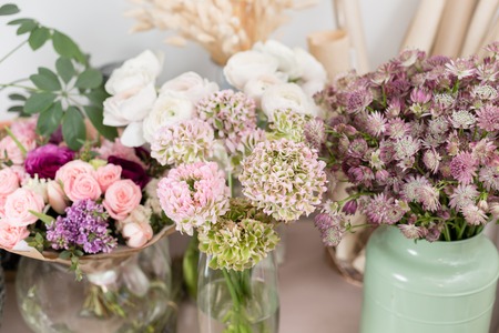 Few of beautiful luxury bouquet. Mixed flowers on pink table. the work of the florist at a flower shop. Weddingの写真素材