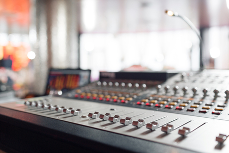 od adjusters and red buttons of a mixing console. It is used for audio signals modifications to achieve the desired output. Applied in recording studios, broadcasting, television.の写真素材