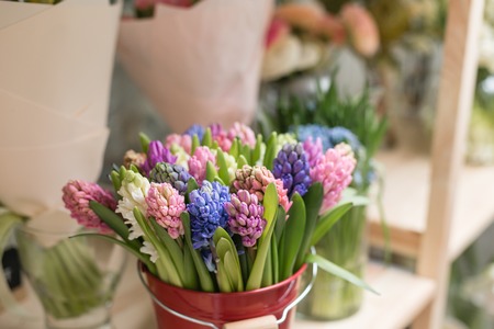 Flower shop concept. Different varieties fresh spring flowers in refrigerator room for flowers. Bouquets on shelf, florist business.の写真素材