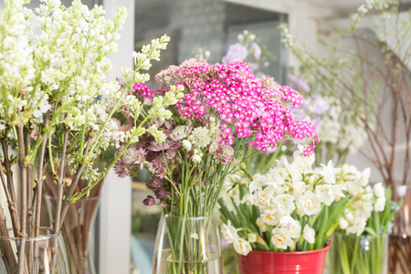 Flower shop concept. Different varieties fresh spring flowers in refrigerator room for flowers. Bouquets on shelf, florist business.の写真素材