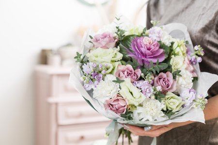 beautiful luxury bouquet of mixed flowers in woman hand. the work of the florist at a flower shop.の写真素材