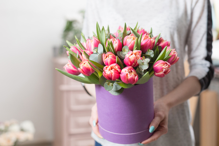 beautiful luxury bouquet of pink tulips flowers in woman hand. the work of the florist at a flower shop.の写真素材
