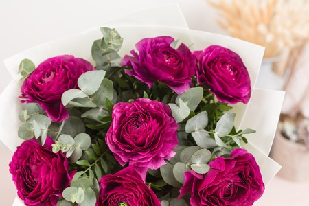 Persian buttercup. lace with many petals. Bunch violet ranunculus flowers light background....