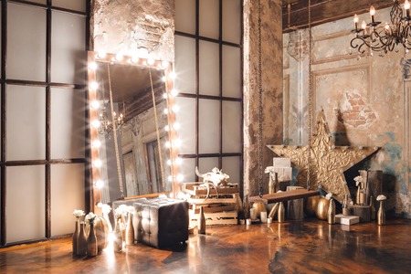 Loft interior with mirror, candles, brick wall, large window, living room, coffee table in modern designの写真素材