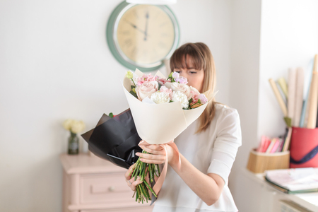 beautiful luxury bouquet of mixed flowers in woman hand. the work of the florist at a flower shop. A small family businessの写真素材