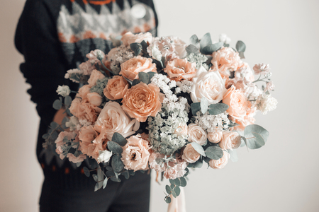 beautiful luxury bouquet of mixed flowers in woman hand. the work of the florist at a flower shop. A small family businessの写真素材