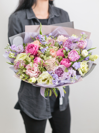 beautiful luxury bouquet of mixed flowers in woman hand. the work of the florist at a flower shop. A...