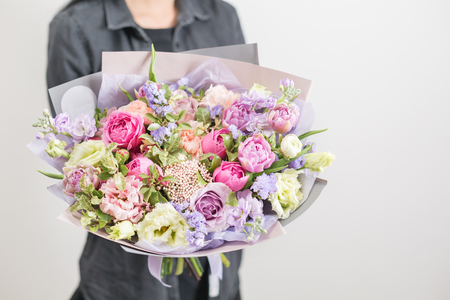 beautiful luxury bouquet of mixed flowers in woman hand. the work of the florist at a flower shop. A small family businessの写真素材