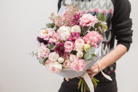 beautiful luxury bouquet of mixed flowers in woman hand. the work of the florist at a flower shop. A small family businessの写真素材