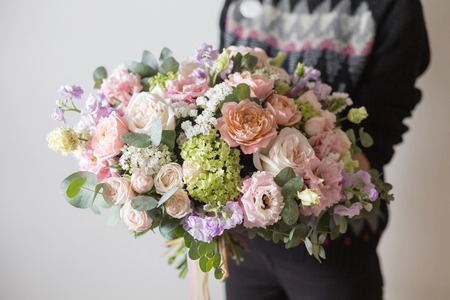 beautiful luxury bouquet of mixed flowers in woman hand. the work of the florist at a flower shop. A small family businessの写真素材