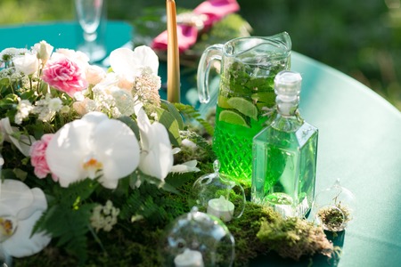 forest decor. Lemonade pitcher with lime, mint and ice on tableの写真素材