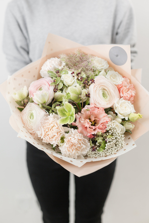 beautiful luxury bouquet of mixed flowers in woman hand. the work of the florist at a flower shop. Vertical photoの写真素材