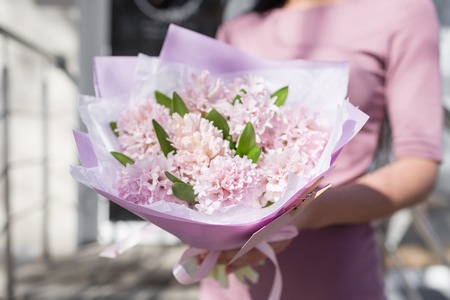 bouquet of beautiful flowers in womens hands. Floristry concept. Spring colors. the work of the florist at a flower shop. Horizontal photoの写真素材