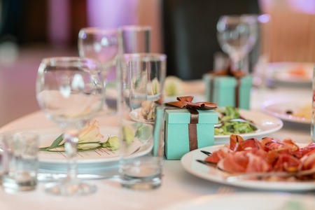 gift box with ribbons. Luxury wedding reception in restaurant. stylish decor and adorning. Restaurant table with foodの写真素材