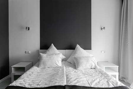 daylight morning. Hotel standart room. modern bedroom with white pillows. simple and stylish interior.の写真素材