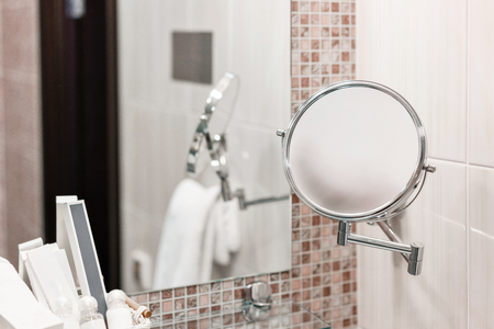 magnifying mirror. Clean white towel and bathrobe on a hanger prepared to use. Bathroom Inside rooms of a apartment or hotel.の写真素材