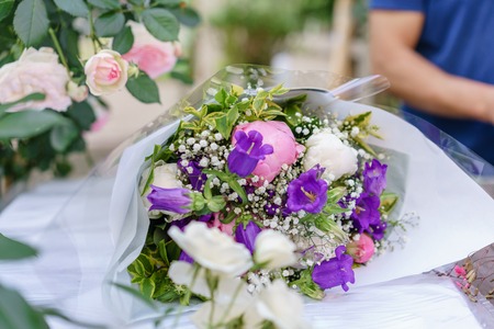 beautiful bouquet in flower shop. outdoor working in flower shop. assistant in floral design studio, making decorations and arrangements.の写真素材