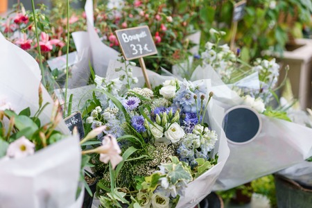 beautiful bouquet in flower shop. outdoor working in flower shop. assistant in floral design studio, making decorations and arrangements.の写真素材