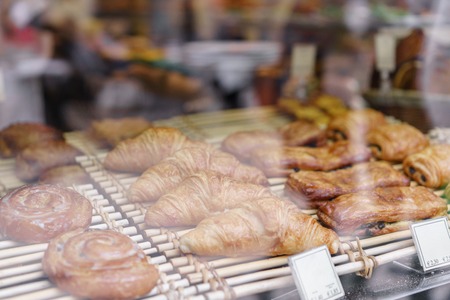 many of croissants. Hot pastries lie on the shelf in the cafe. Buns and bagels in the store.の写真素材