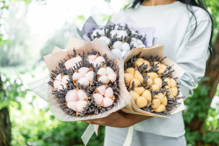 three beautiful and different bouquets lavender with cotton in woman hands . dried flowers lilac color. placed in a paper bag. colorful color mix flower.の写真素材