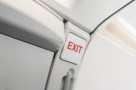 emergency exit sign on airplane. Empty airplane seats in the cabin. Modern Transportation concept. Aircraft long-distance international flightの写真素材