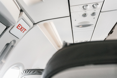 emergency exit sign on airplane. Empty airplane seats in the cabin. Modern Transportation concept....