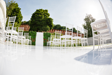 Place of wedding ceremony. Wedding decor, , details of wedding arch, floristics, chairs and a path of mirror white coating.の写真素材