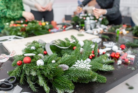 Manufacturer of Christmas wreath from branches of pine for holiday. Master class on making decorative ornaments. Christmas decor with their own hands. The new year celebration. Flower shopの写真素材