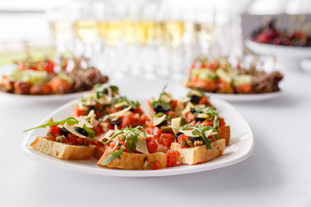 Plate with Italian appetizers. Bruschetta with a cherry tomatoes and shrimps. Parmesan cheese,...