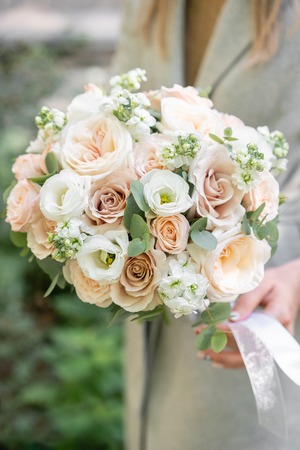spring mood. Young girl holding a beautiful wedding bouquet. flower arrangement with white and...