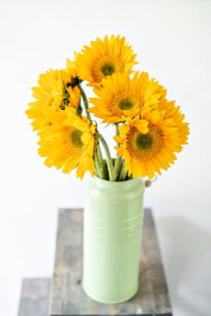 Bouquet of yellow sunflowers , flower in vase on old vintage table. Room morning. Gray background. Colors of autumn and mood fallの写真素材