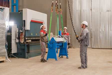 Production of ventilation and drainpipe. Workers adjusts the machine in the warehouse. the...