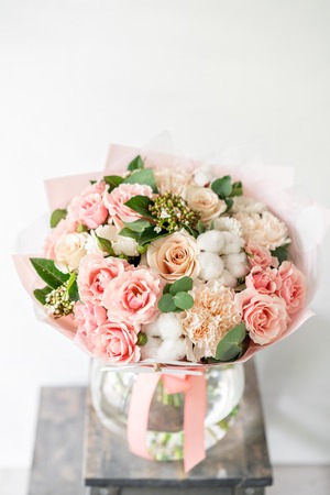 beautiful spring bouquet. flowers arrangement with various of colors in glass vase on old table. bright roomの素材 [FY310110922870]