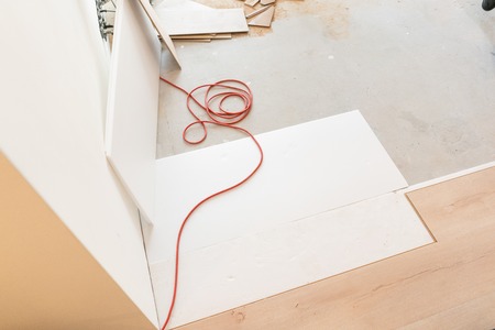 Installing laminate parquet in interior. On the floor lie different carpenter tools. Hammer and...