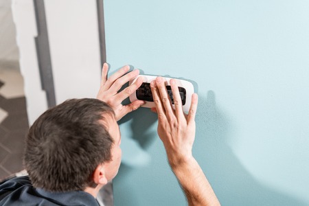 A young electrician installing an electrical socket in a new house.の写真素材