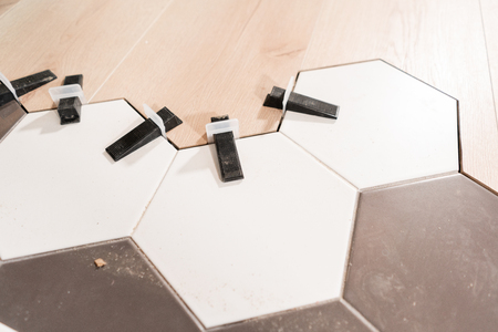 The combination of wood panels of laminate and ceramic tiles in the form of honeycomb. Kitchen renovation. concept of repair in house.の写真素材