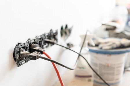 Work gloves in the foreground. Lots of tools and cans of paint in the background. Concept of repair in the houseの写真素材